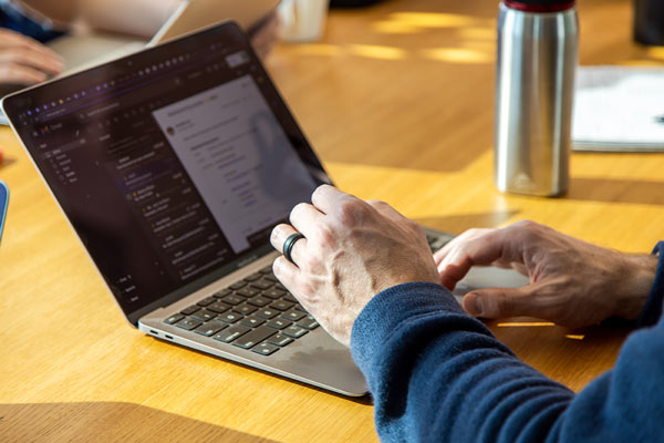 Two hands typing on a laptop keyboard. 