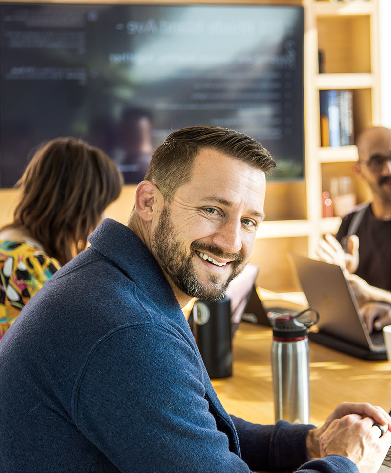 A person sitting at a table smiling at the camera.