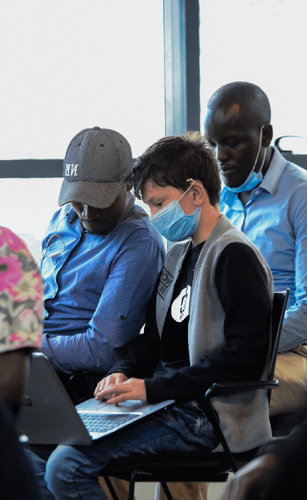 Three people sitting together working on laptops. 