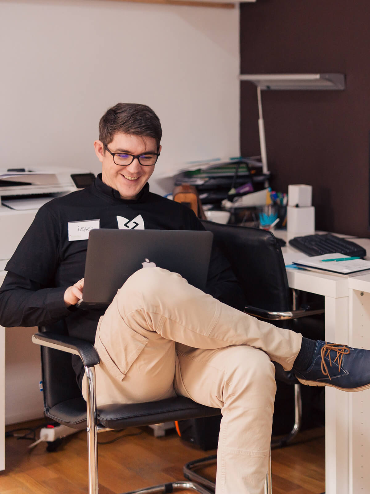 A person sitting in a chair using a laptop.