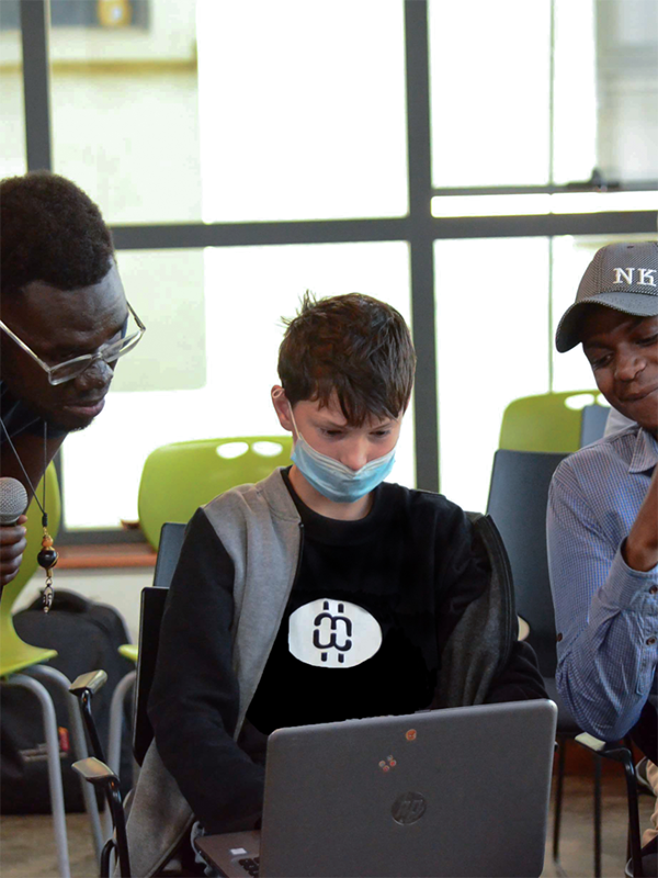 Three people looking at laptop