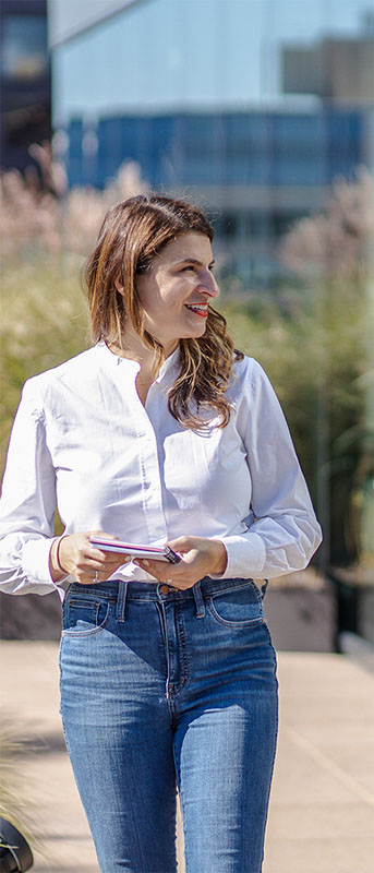 A woman walking with a notebook. 